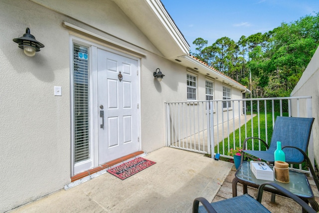 2853 White Trout Ln, West Palm Beach, FL 33411 - view of exterior entry with stucco siding and a balcony