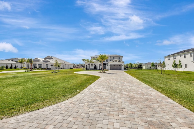 exterior space featuring decorative driveway, a residential view, a lawn, and a garage