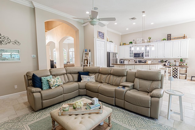 living area featuring visible vents, crown molding, ceiling fan, baseboards, and arched walkways