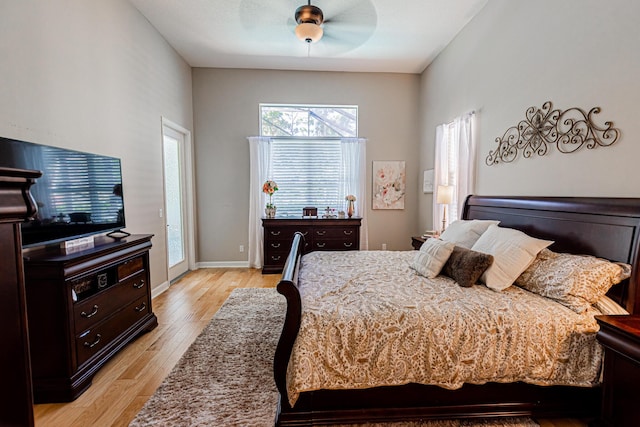 bedroom featuring light wood finished floors, a ceiling fan, and baseboards