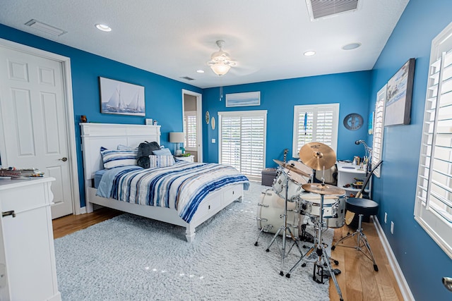 bedroom featuring visible vents, baseboards, and wood finished floors