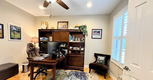 home office with baseboards, light wood-style flooring, and a ceiling fan