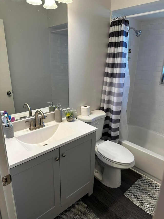 bathroom with toilet, wood finished floors, vanity, and shower / bath combination with curtain