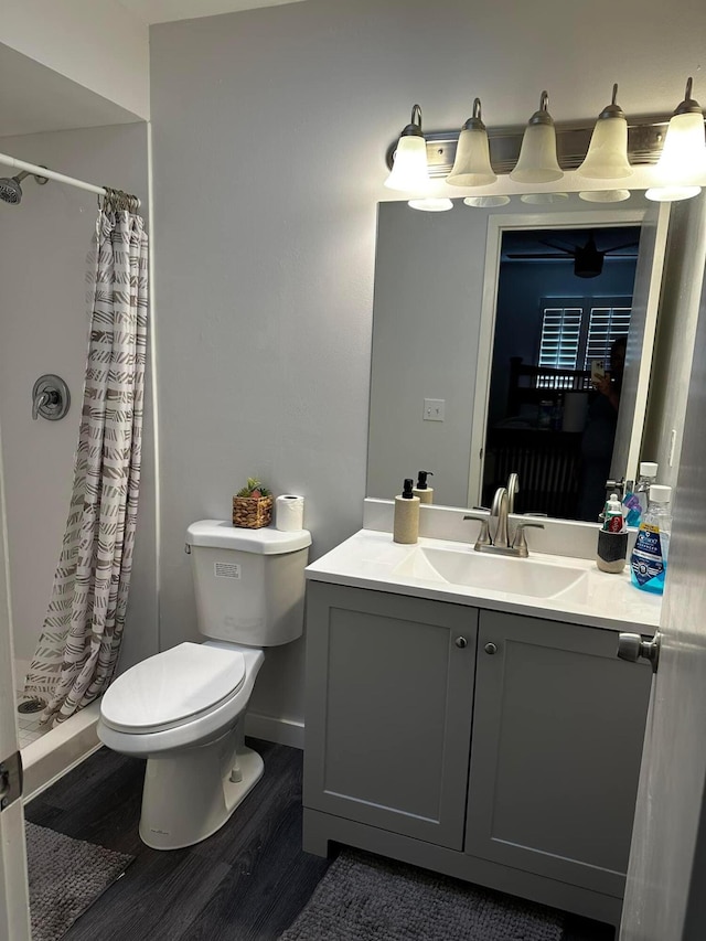 full bath featuring a shower with shower curtain, toilet, vanity, and wood finished floors