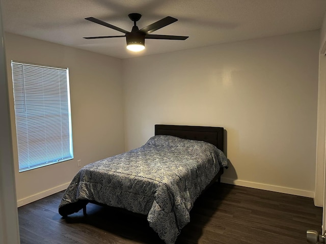 bedroom featuring dark wood-style floors, a textured ceiling, a ceiling fan, and baseboards