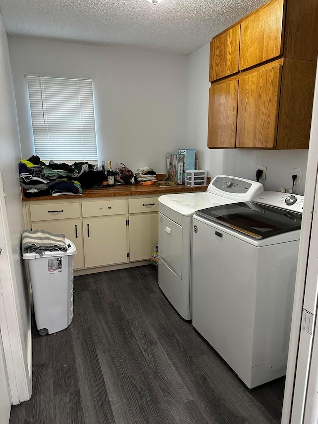 laundry room featuring dark wood finished floors, cabinet space, a textured ceiling, and separate washer and dryer