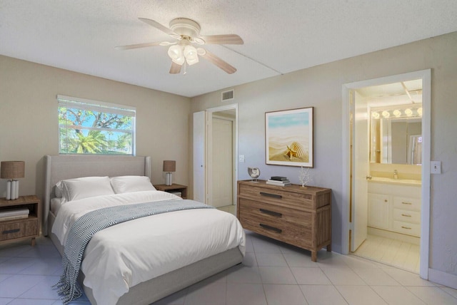 406 Flanders I, Delray Beach, FL 33484 - bedroom with light tile patterned flooring, connected bathroom, ceiling fan, a sink, and a textured ceiling