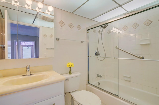 full bathroom with toilet, vanity, and bath / shower combo with glass door