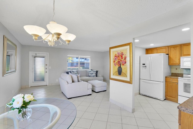 living room with light tile patterned floors, a notable chandelier, a textured ceiling, and baseboards