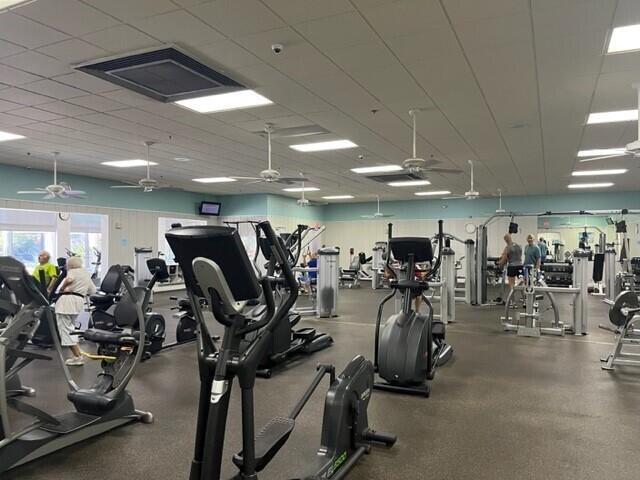 gym with visible vents, a paneled ceiling, and ceiling fan