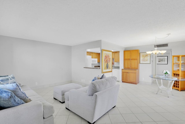 living room with visible vents, baseboards, a chandelier, and light tile patterned flooring