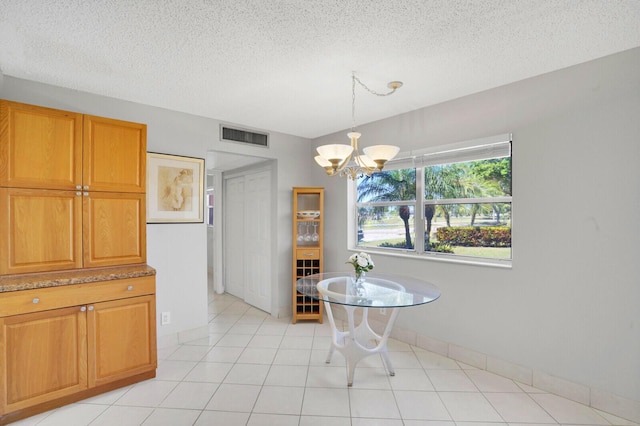 dining room featuring visible vents, baseboards, light tile patterned flooring, a notable chandelier, and a textured ceiling