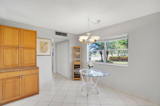 406 Flanders I, Delray Beach, FL 33484 - dining area featuring a chandelier, a textured ceiling, and baseboards