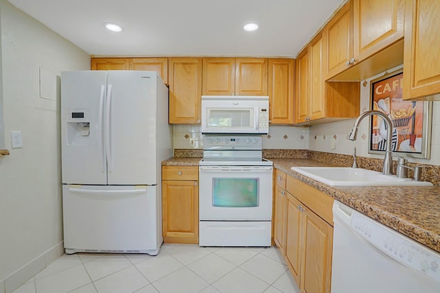 kitchen featuring light tile patterned floors, white appliances, tasteful backsplash, and a sink