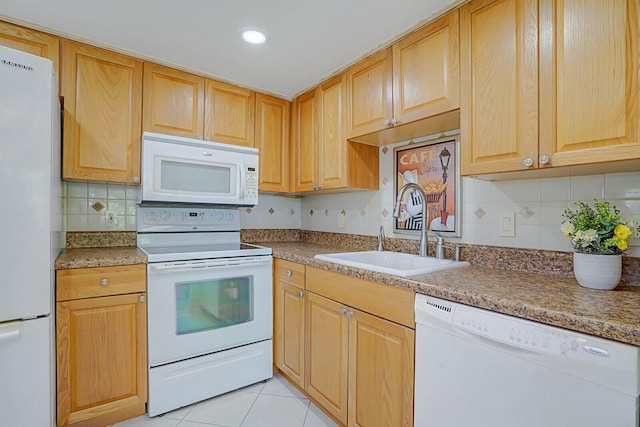 kitchen featuring tasteful backsplash, light brown cabinetry, light tile patterned floors, white appliances, and a sink