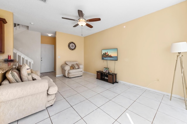 unfurnished living room with light tile patterned floors, stairway, baseboards, and ceiling fan