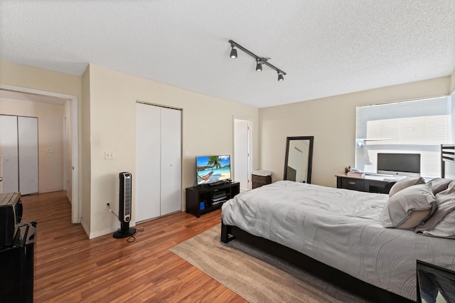 bedroom featuring a closet, a textured ceiling, and wood finished floors