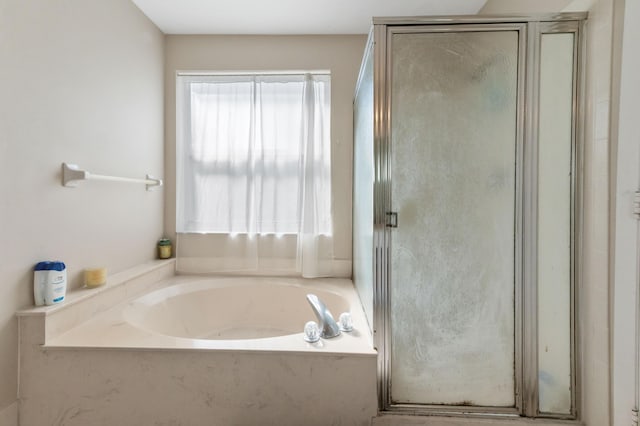 full bathroom featuring a shower stall and a garden tub