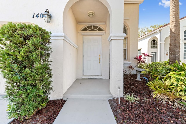 doorway to property featuring stucco siding