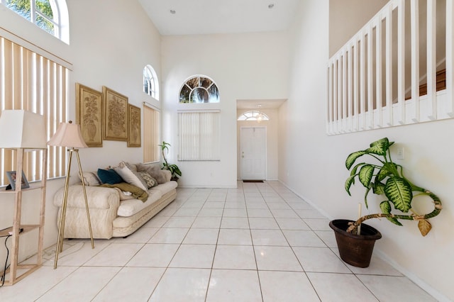 foyer with a high ceiling, light tile patterned floors, and baseboards