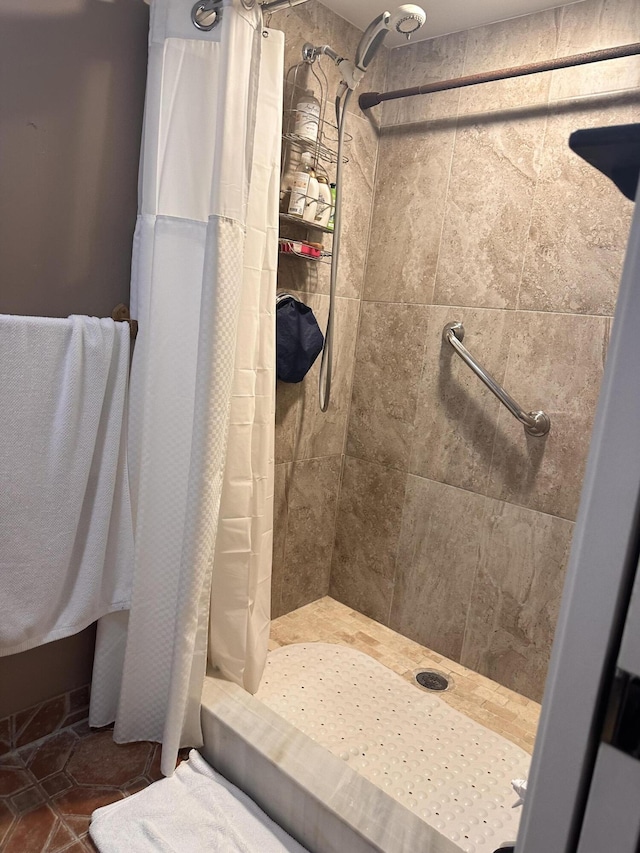 bathroom featuring tile patterned flooring and a tile shower