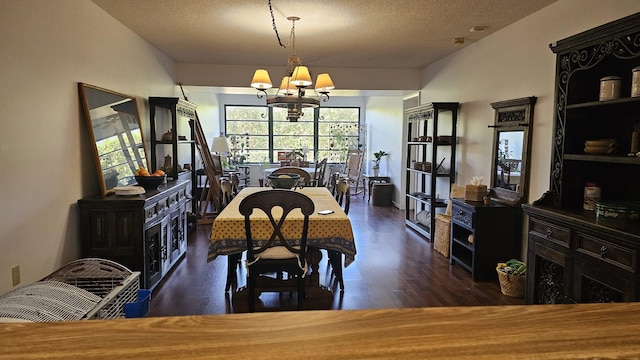 dining area featuring a textured ceiling, wood finished floors, and a chandelier