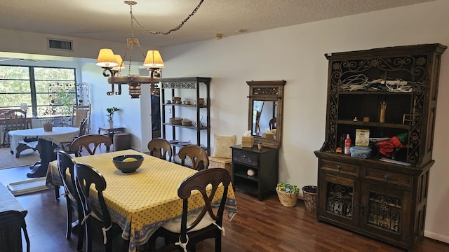 dining area featuring a textured ceiling, dark wood-style floors, a chandelier, and visible vents