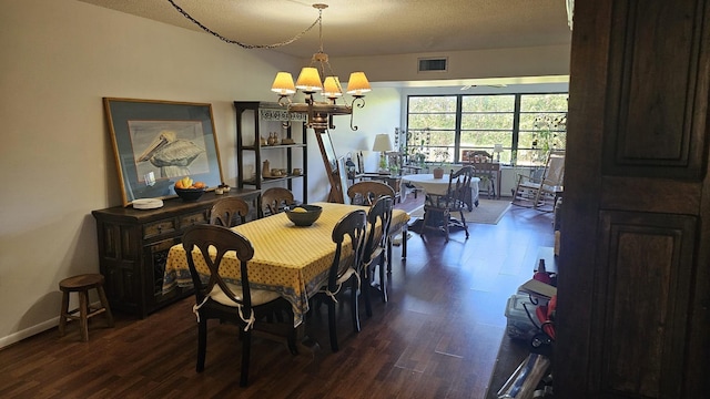 dining area featuring a chandelier, a textured ceiling, baseboards, visible vents, and dark wood-style flooring
