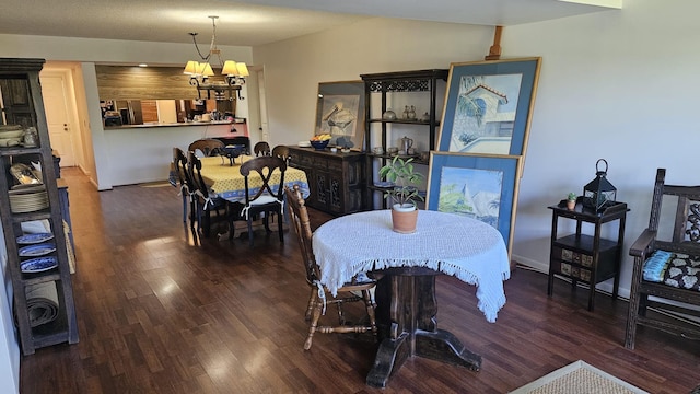 dining area with baseboards, vaulted ceiling, wood finished floors, and a chandelier