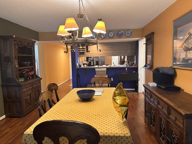 dining space with wood finished floors, a textured ceiling, and a chandelier