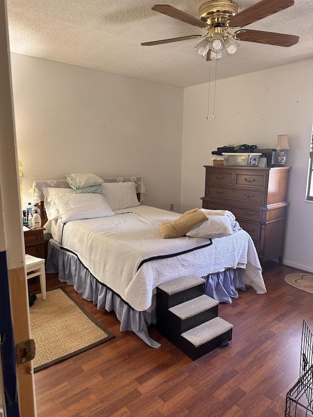 bedroom featuring a ceiling fan, wood finished floors, and a textured ceiling