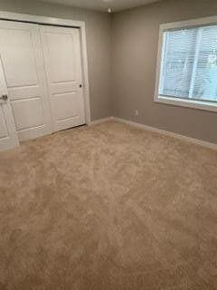 unfurnished bedroom with a closet, baseboards, and carpet