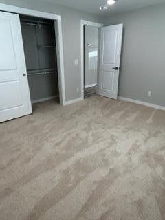 unfurnished bedroom with baseboards and carpet floors