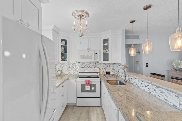 kitchen with visible vents, a sink, tasteful backsplash, white cabinetry, and white appliances