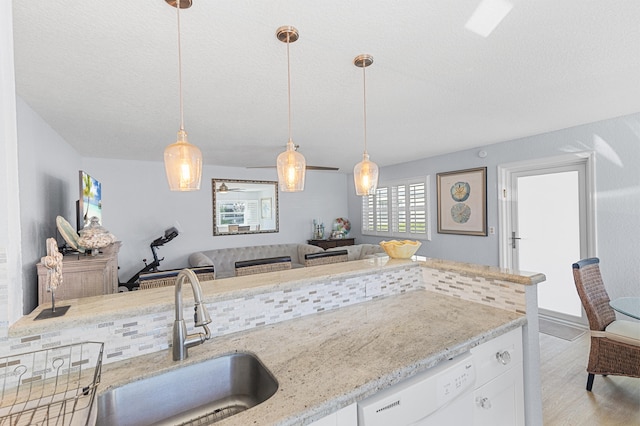 kitchen featuring a sink, light stone countertops, and white dishwasher