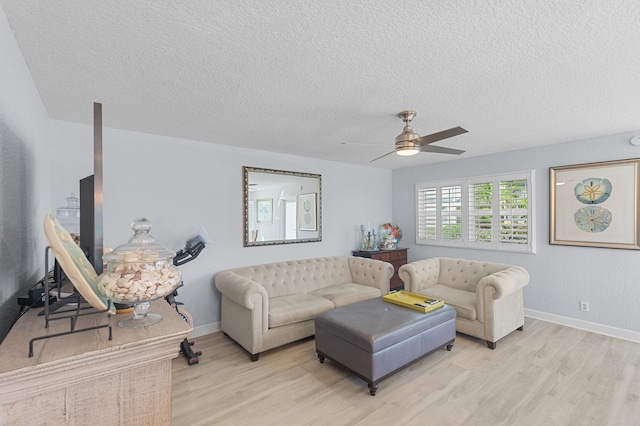 living area with a ceiling fan, baseboards, light wood finished floors, and a textured ceiling