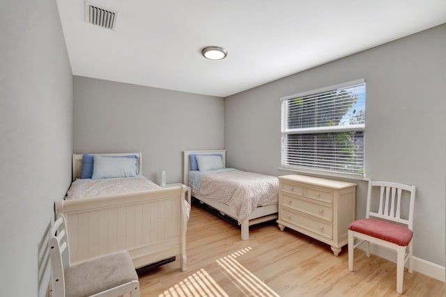 bedroom featuring visible vents, baseboards, and light wood-type flooring