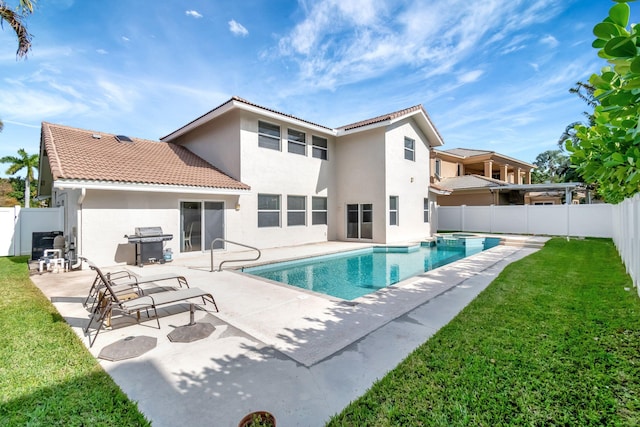 rear view of house featuring a lawn, a tile roof, a fenced backyard, and stucco siding
