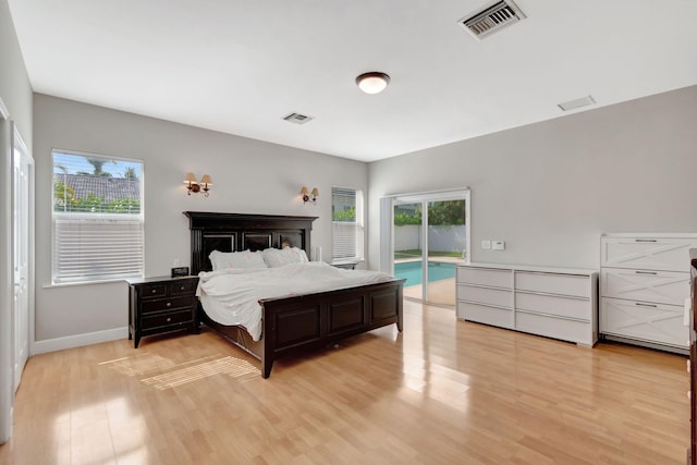 bedroom featuring baseboards, access to exterior, light wood-type flooring, and visible vents