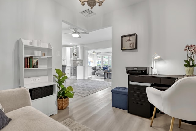 home office featuring visible vents, a ceiling fan, and wood finished floors