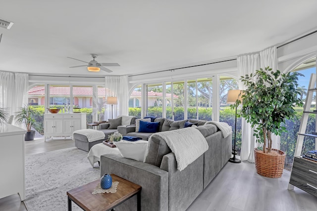 living room with a healthy amount of sunlight, wood finished floors, and a ceiling fan