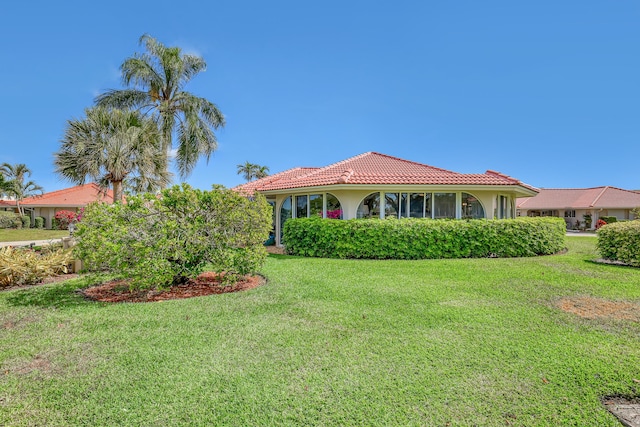 view of front of home with stucco siding, a front lawn, and a tile roof