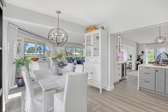 dining room with a chandelier, a healthy amount of sunlight, and light wood-style flooring