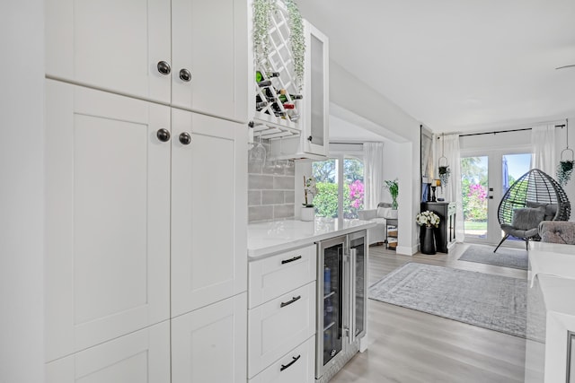 kitchen featuring decorative backsplash, plenty of natural light, light wood-type flooring, and white cabinetry