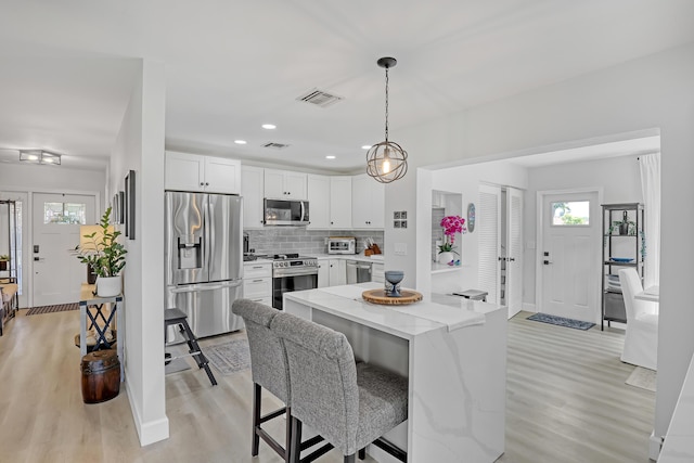 dining space with recessed lighting, light wood-style floors, visible vents, and baseboards
