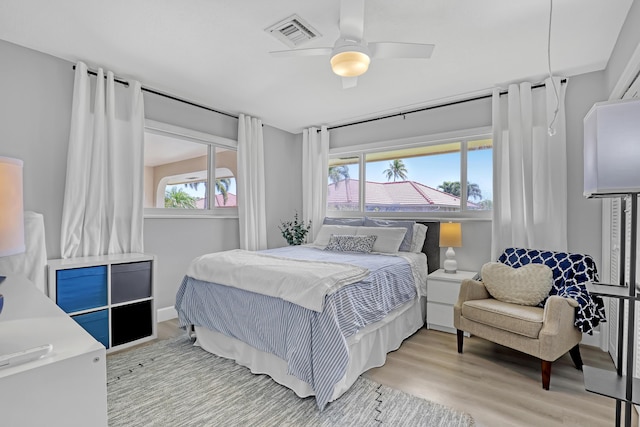 bedroom with visible vents, a ceiling fan, and wood finished floors