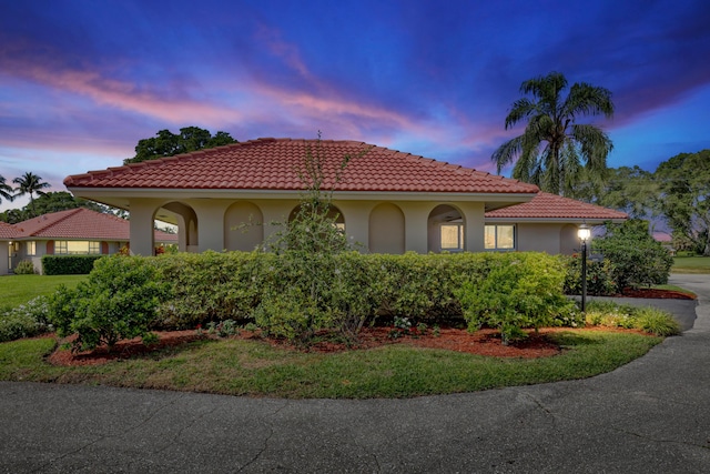 mediterranean / spanish house featuring stucco siding and a tiled roof