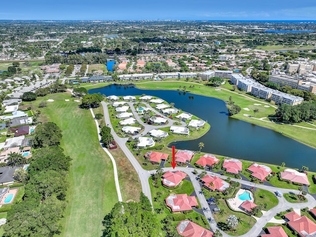 drone / aerial view featuring view of golf course, a water view, and a residential view