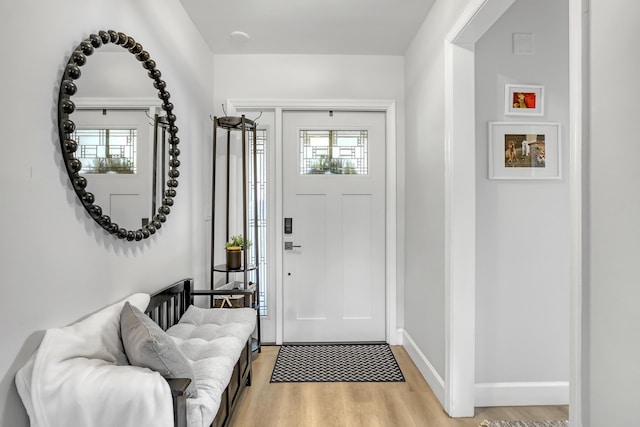 foyer entrance featuring light wood finished floors and baseboards