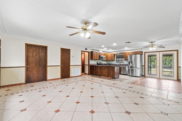 kitchen with visible vents, ceiling fan, open floor plan, ornamental molding, and stainless steel appliances